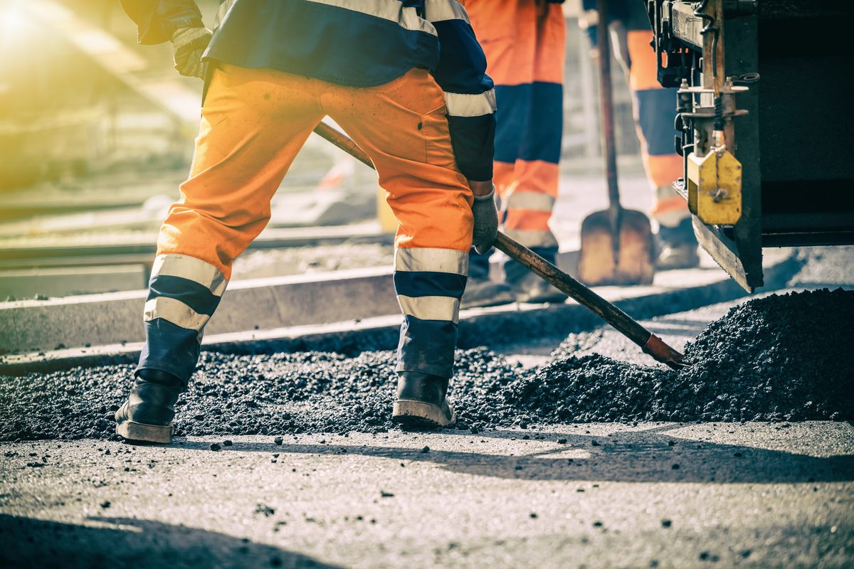 Ouvrier du groupe Joly étalant de l'enrobé sur un chantier de voirie