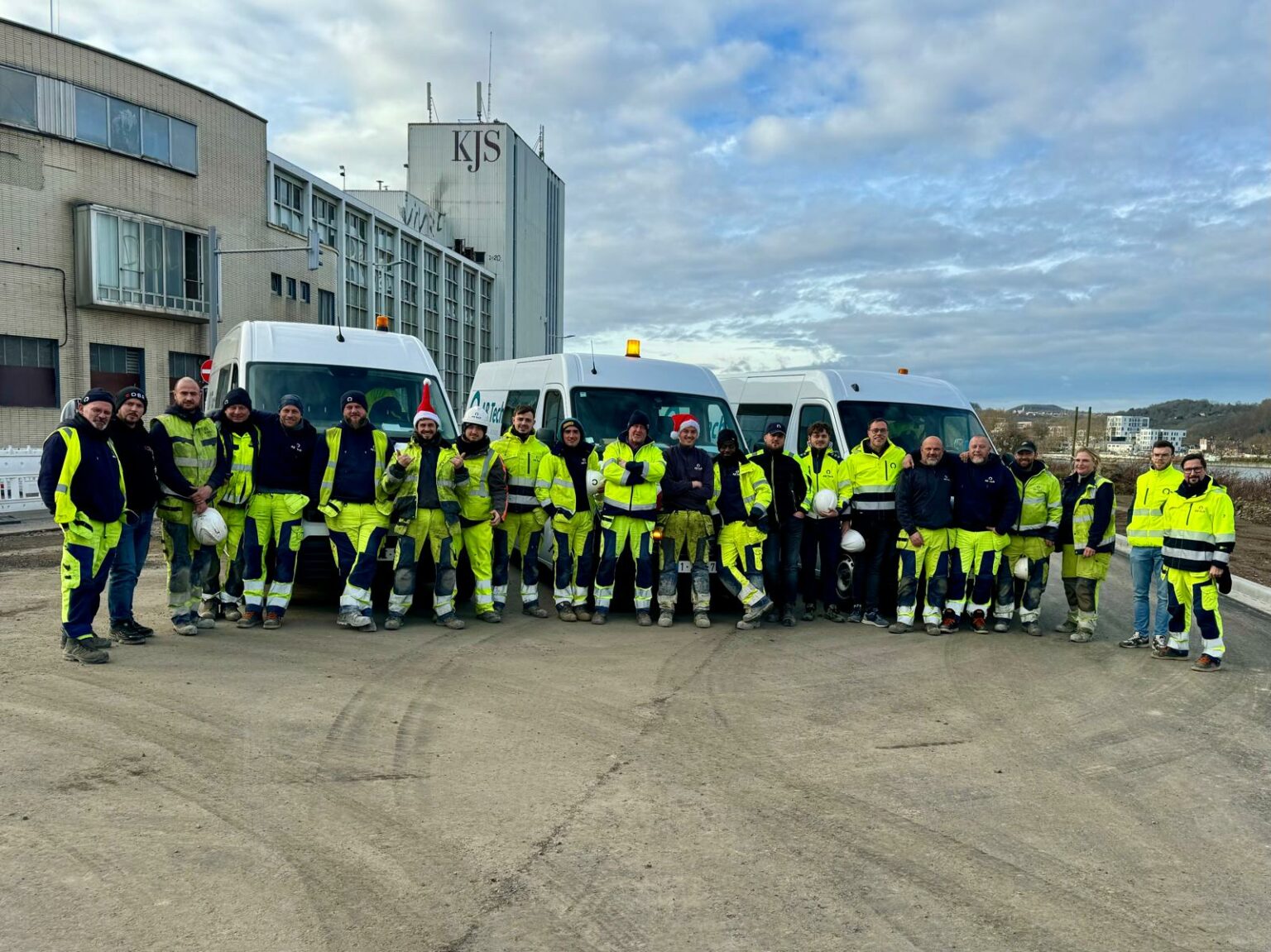 L'équipe du groupe Joly en tenue de chantier devant ses camionnettes
